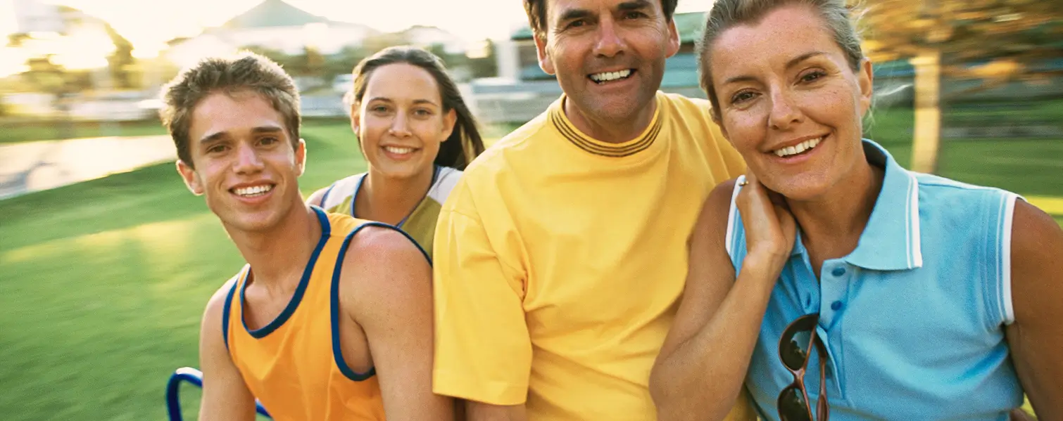 A family taking a self-portrait photograph in a park.